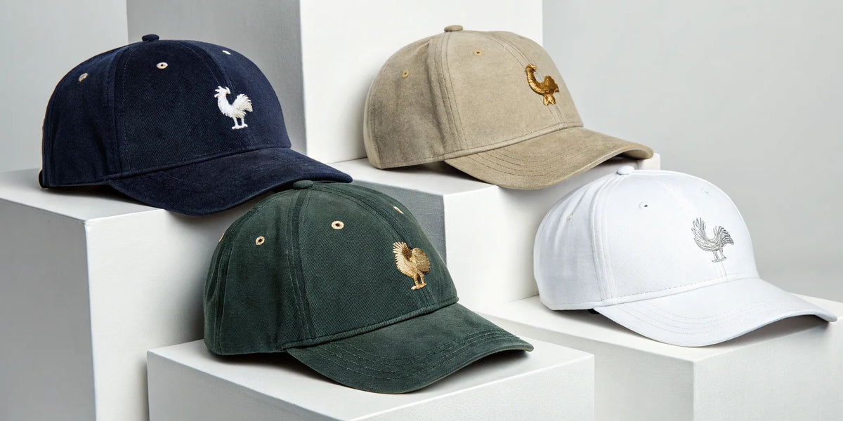 Beisbol Gallo Fino embroidered hats in navy, tan, green, and white.