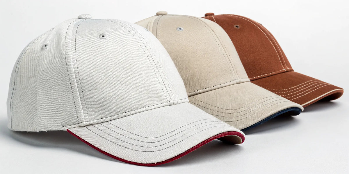 A collection of Texans Dandy beisbol hats in white, beige, and brown.