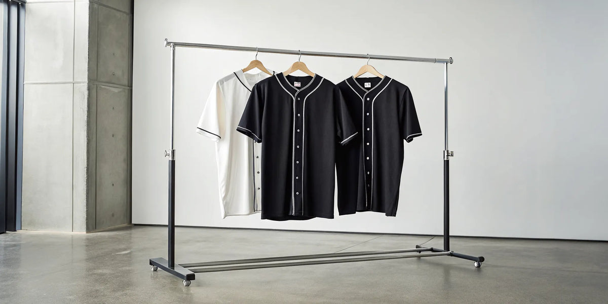 A rack of black and white Zacatecas baseball jerseys in a classic button-down style.