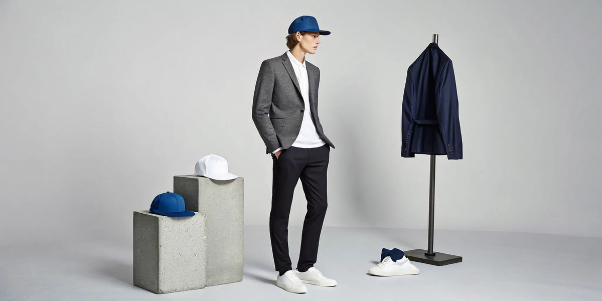 Man styling a beisbol Dodgers Dandy hat with a blazer and sneakers among a collection of Dandy hats.